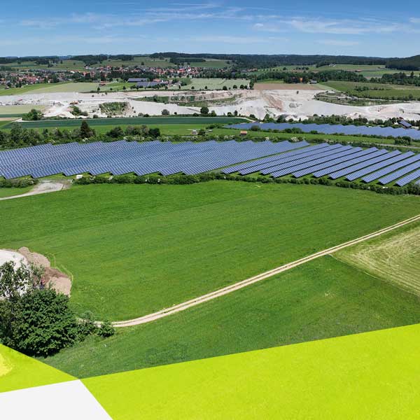 Two green fields separated by a path. And in the background is a solar farm.